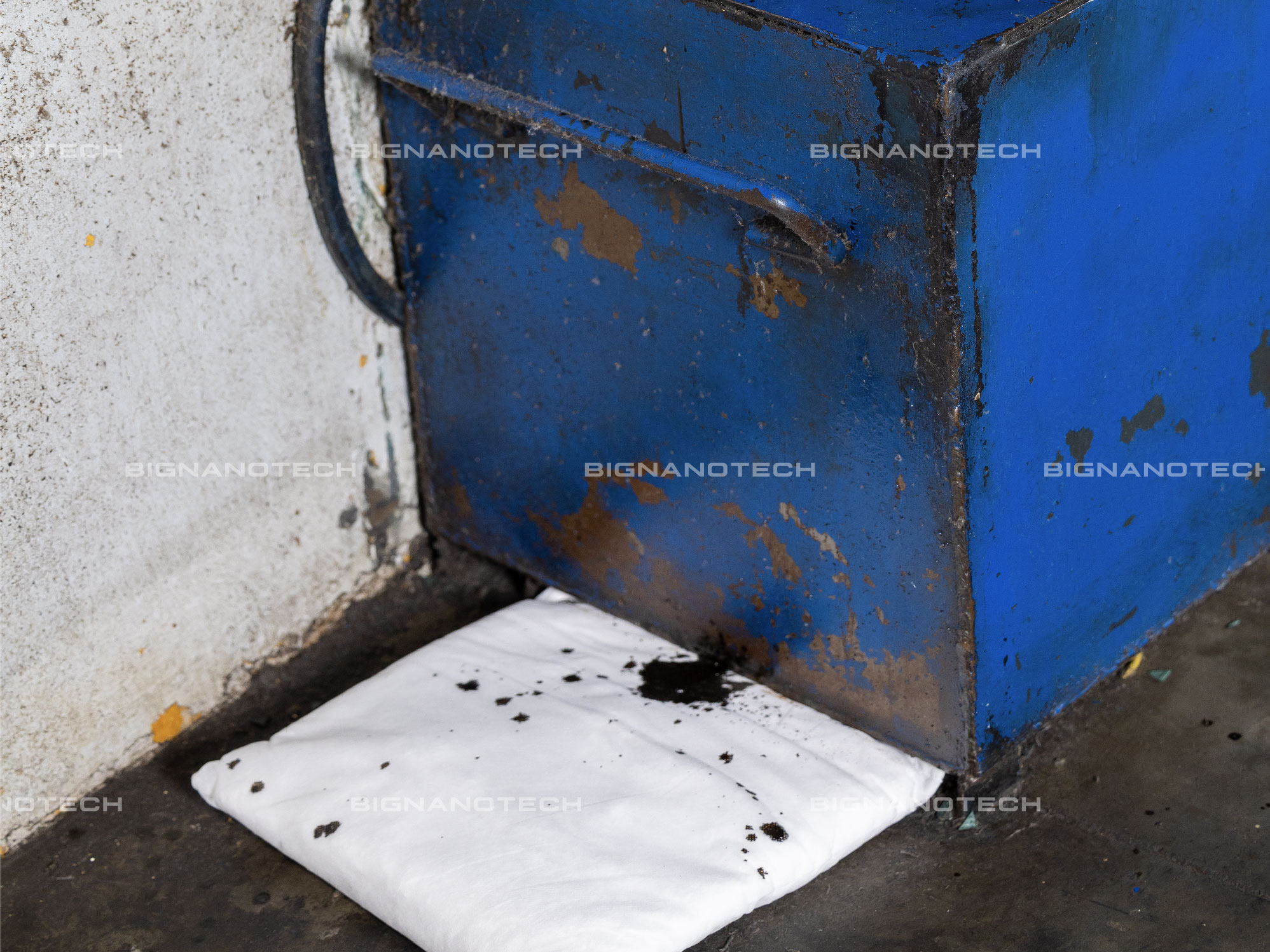 Gối thấm dầu N-Fiber đặt dưới máy móc công nghiệp, nhỏ gọn và tiện lợi trong xử lý dầu tràn tại các khu vực nhỏ hẹp